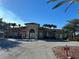 Exterior view of the community clubhouse, palm trees, tile roof, and dedicated parking at 2550 Bella Vista Dr, Davenport, FL 33897