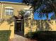 Two story tan townhome, arched windows, red tile entry roof, brick walkway and green landscaping at 2550 Bella Vista Dr, Davenport, FL 33897