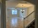 Inviting living room with tile flooring, chandelier, and staircase leading to the upper level at 2550 Bella Vista Dr, Davenport, FL 33897