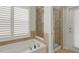 Bathroom featuring a bathtub and a separate glass-door shower with tan tile surround at 265 Del Sol Ave, Davenport, FL 33837