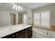 Bathroom featuring double sinks, white shutters, a garden tub, and a glass-door shower at 265 Del Sol Ave, Davenport, FL 33837