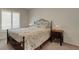 Bedroom featuring neutral carpeting, a bed with a metal headboard and matching bedside tables and lamps at 265 Del Sol Ave, Davenport, FL 33837