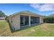 Rear exterior of property features a screened-in lanai and lush lawn at 265 Del Sol Ave, Davenport, FL 33837