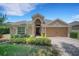 Inviting single-Gathering home featuring a well-manicured lawn and a brick driveway at 265 Del Sol Ave, Davenport, FL 33837