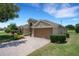 Well-maintained home featuring a brick driveway, lush lawn, and a two-car garage at 265 Del Sol Ave, Davenport, FL 33837