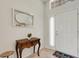 Inviting entryway featuring a decorative table, mirror, and a welcoming white door at 265 Del Sol Ave, Davenport, FL 33837