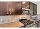 Well-lit kitchen with stainless steel appliances, sleek dark cabinetry, and tile backsplash at 265 Del Sol Ave, Davenport, FL 33837