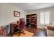 Home office with hardwood floors, built-in bookshelves, and a window with white shutters at 265 Del Sol Ave, Davenport, FL 33837