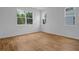 A bright, empty bedroom with tile floors and two windows overlooking trees at 317 Alexandrite St, Deland, FL 32720
