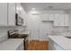 Bright kitchen with white cabinets, stainless steel appliances, and wood-style floors at 317 Alexandrite St, Deland, FL 32720