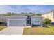 Charming single-story home boasts a well-manicured lawn, gray paint and an attached two-car garage at 3633 Bristol Cove Ln, St Cloud, FL 34772