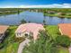 Beautiful lakefront home featuring lush landscaping, a brick paver driveway, and terra cotta roof in a serene community at 644 Shorehaven Dr, Kissimmee, FL 34759