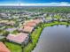 Aerial view shows neighborhood homes bordering a lake and features a view of the surrounding landscape at 644 Shorehaven Dr, Kissimmee, FL 34759