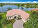 Beautiful lakefront home with mature landscaping, brick paver driveway, and terra cotta roof in a serene community at 644 Shorehaven Dr, Kissimmee, FL 34759