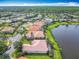 An aerial view captures a residential neighborhood nestled alongside a serene lake and mature trees at 644 Shorehaven Dr, Kissimmee, FL 34759