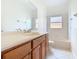 Well-lit bathroom showcasing a wood vanity, neutral countertop, and a bathtub-shower combination at 644 Shorehaven Dr, Kissimmee, FL 34759