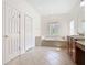 Spacious bathroom featuring tile flooring, a large soaking tub, and wood cabinets at 644 Shorehaven Dr, Kissimmee, FL 34759