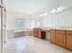 Bright bathroom with tile flooring, a soaking tub, and dual sinks with wood cabinets at 644 Shorehaven Dr, Kissimmee, FL 34759