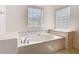 Bright bathroom features a soaking tub with tile surround and multiple windows at 644 Shorehaven Dr, Kissimmee, FL 34759