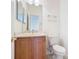 Compact bathroom with a wood vanity, sink, toilet, mirror, and towel rack, designed for functionality at 644 Shorehaven Dr, Kissimmee, FL 34759
