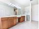 Bathroom with tiled floor, double vanity with wood cabinets, and glass-enclosed shower at 644 Shorehaven Dr, Kissimmee, FL 34759