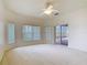 Large bedroom with neutral carpet, a ceiling fan, and sliding glass doors to the lanai at 644 Shorehaven Dr, Kissimmee, FL 34759