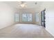 Spacious bedroom with neutral carpet, a ceiling fan, and lots of natural light from large windows at 644 Shorehaven Dr, Kissimmee, FL 34759