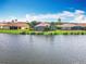 Waterfront homes featuring terra cotta roofs and lush landscaping against a backdrop of clear blue skies at 644 Shorehaven Dr, Kissimmee, FL 34759