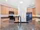 Bright kitchen featuring granite countertops, light wood cabinets, and stainless-steel sink with dark faucet at 644 Shorehaven Dr, Kissimmee, FL 34759