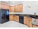 Updated kitchen with light wood cabinets, granite countertops, and modern black appliances at 644 Shorehaven Dr, Kissimmee, FL 34759