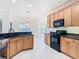 Eat-in kitchen with granite countertops, wood cabinetry, and black appliances overlooking the backyard at 644 Shorehaven Dr, Kissimmee, FL 34759