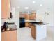 Spacious kitchen with light wood cabinetry, black appliances, granite counters, and an open floor plan at 644 Shorehaven Dr, Kissimmee, FL 34759