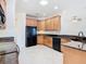 Updated kitchen features light wood cabinets, modern black appliances, and a bright skylight at 644 Shorehaven Dr, Kissimmee, FL 34759