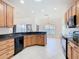 Eat-in kitchen featuring granite counters, tile flooring, wood cabinetry, and black appliances at 644 Shorehaven Dr, Kissimmee, FL 34759