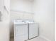 Convenient laundry room with washer, dryer, and a wire shelf for storage at 644 Shorehaven Dr, Kissimmee, FL 34759