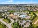 Aerial view of a luxurious community pool area with palm trees, lounging chairs, and a clubhouse at 860 Pebble Beach Dr, Davenport, FL 33896