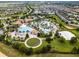 Birds eye view of a community pool with palm trees, poolside seating, and a sand volleyball court at 860 Pebble Beach Dr, Davenport, FL 33896