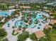 Overhead view of a pool with lush landscaping, cabanas, and a lazy river for relaxing and recreation at 860 Pebble Beach Dr, Davenport, FL 33896