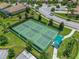 Aerial view of green pickleball courts surrounded by a black fence and lush greenery in a residential community at 860 Pebble Beach Dr, Davenport, FL 33896