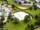 Aerial view of a sand volleyball court next to a community pool with palm trees and lush landscaping at 860 Pebble Beach Dr, Davenport, FL 33896