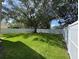 Spacious backyard featuring a lush lawn and white fence, offering privacy and room for outdoor activities at 9846 Palmetto Dunes Ct, Orlando, FL 32832