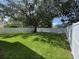 Spacious backyard featuring a well-maintained lawn and a white fence, great for outdoor activities at 9846 Palmetto Dunes Ct, Orlando, FL 32832