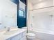 Bathroom with a white vanity, tub with shower and a dark blue accent wall at 1326 Butterfly Orchid Rd, Davenport, FL 33837