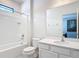 Bright bathroom showcasing the shower-tub combination and vanity with modern fixtures and white finishes at 1326 Butterfly Orchid Rd, Davenport, FL 33837
