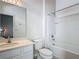 This bathroom features a tub, shower, toilet, a vanity with a sink, and a large mirror at 1326 Butterfly Orchid Rd, Davenport, FL 33837