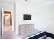 Minimalist bedroom featuring neutral walls, sleek dresser, and ample natural light at 1326 Butterfly Orchid Rd, Davenport, FL 33837