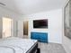 Bright bedroom features a striking blue dresser beneath a wall-mounted television and modern decor at 1326 Butterfly Orchid Rd, Davenport, FL 33837