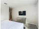 Bedroom with a bed, grey carpet, a dresser and a wall mounted TV at 1326 Butterfly Orchid Rd, Davenport, FL 33837