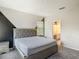 Bedroom with a bed, grey carpet, and an ensuite bathroom at 1326 Butterfly Orchid Rd, Davenport, FL 33837