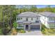 Elegant two-story home boasts mature trees, a gray tile roof, a stone-accented entrance, and a two-car garage at 1326 Butterfly Orchid Rd, Davenport, FL 33837